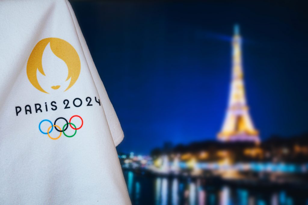 a view of the paris 2024 Olympic flag, the Eiffel tower in the background