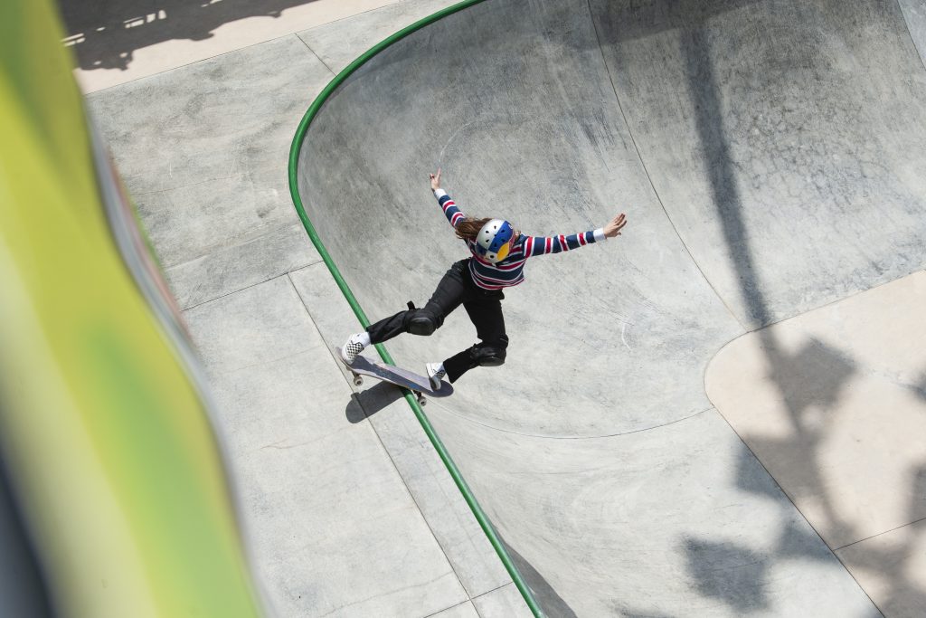 a skateboarder rides up the side of a park